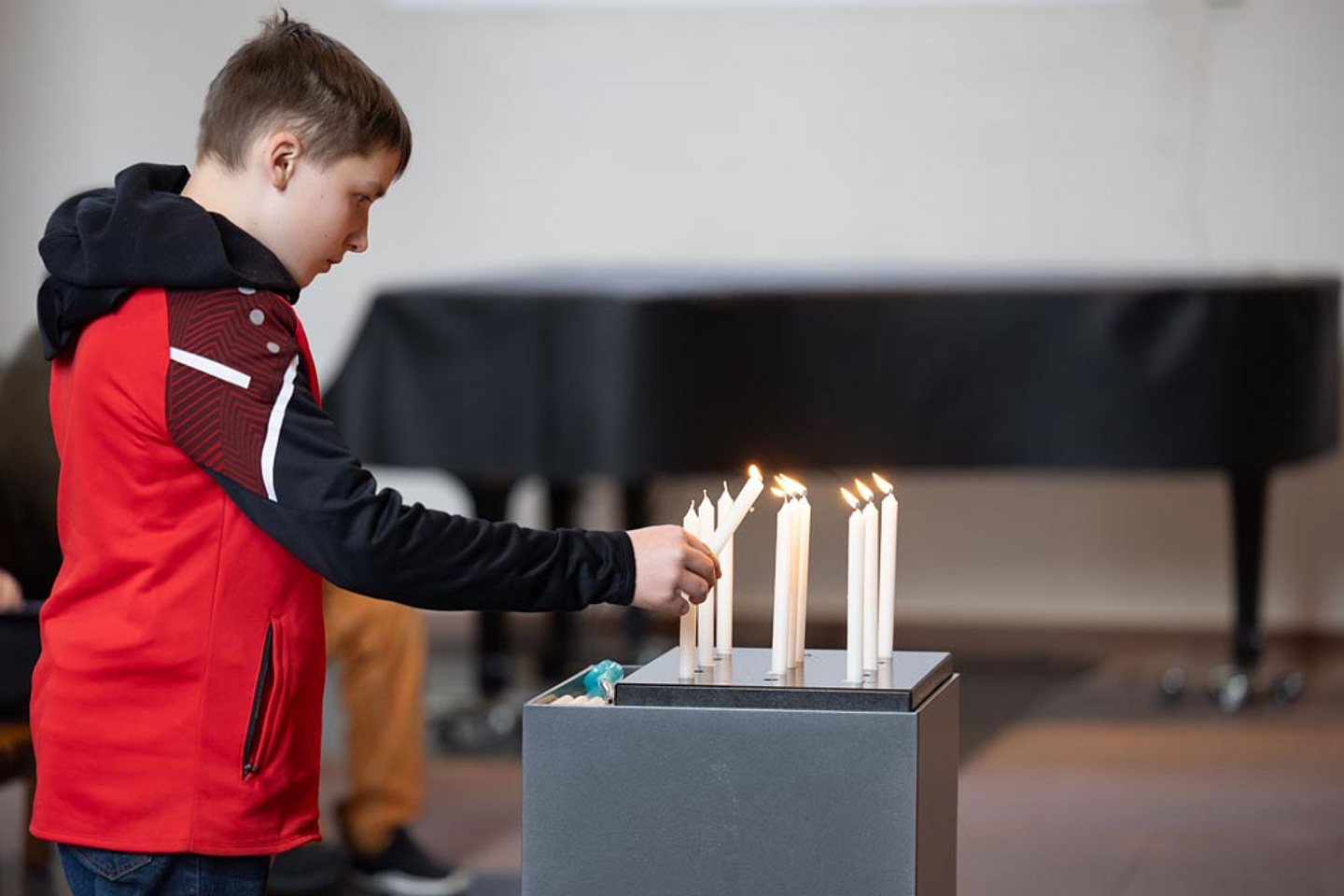 Gemeindemitglieder zündeten für die Opfer zum Gedenken Kerzen auf einer Stele an