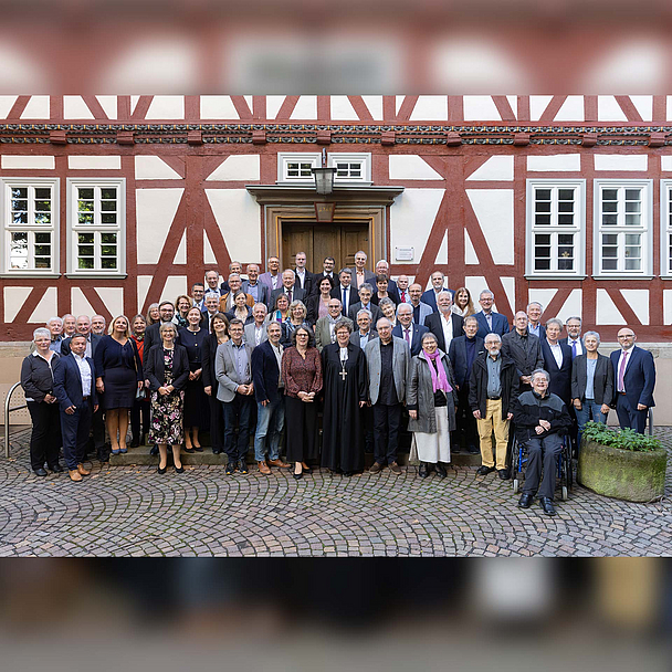 Eine größere Gruppe von Menschen steht vor einem Fachwerkgebäude in Bad Hersfeld. In der vorderen Reihe in der Mitte steht Bischöfin Dr. Beate Hofmann. Links neben ihr steht Pfarrerin Bettina von Haugwitz, die Vorsitzende des Pfarrvereins. Es handelt sich um die Jubilarinnen und Jubilare der Ordinationsjahrgänge, die gemeinsam für ein Gruppenfoto posieren.