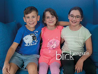 Onno, Franziska und Amelie auf einem blauen Sofa