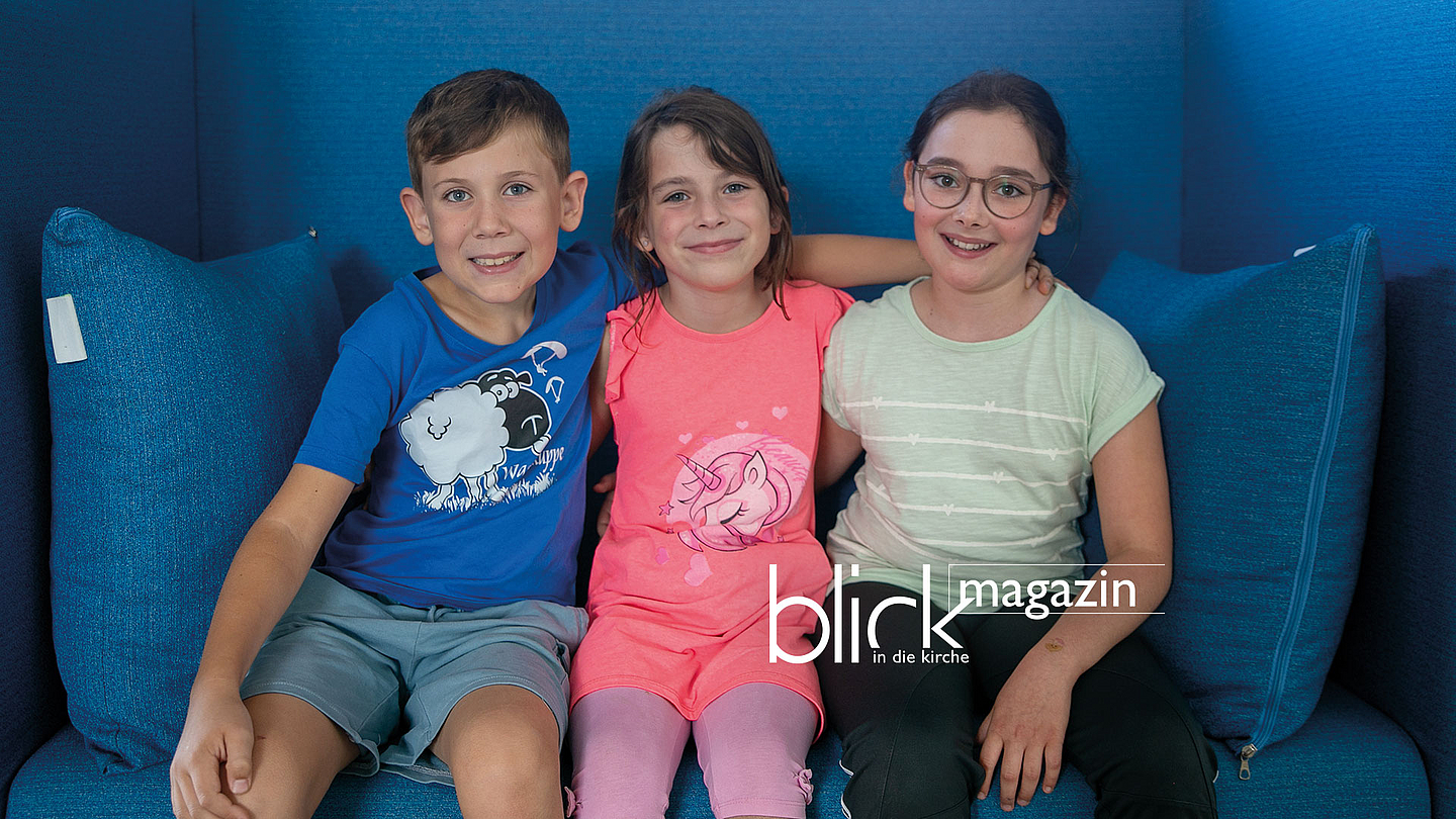 Onno, Franziska und Amelie auf einem blauen Sofa