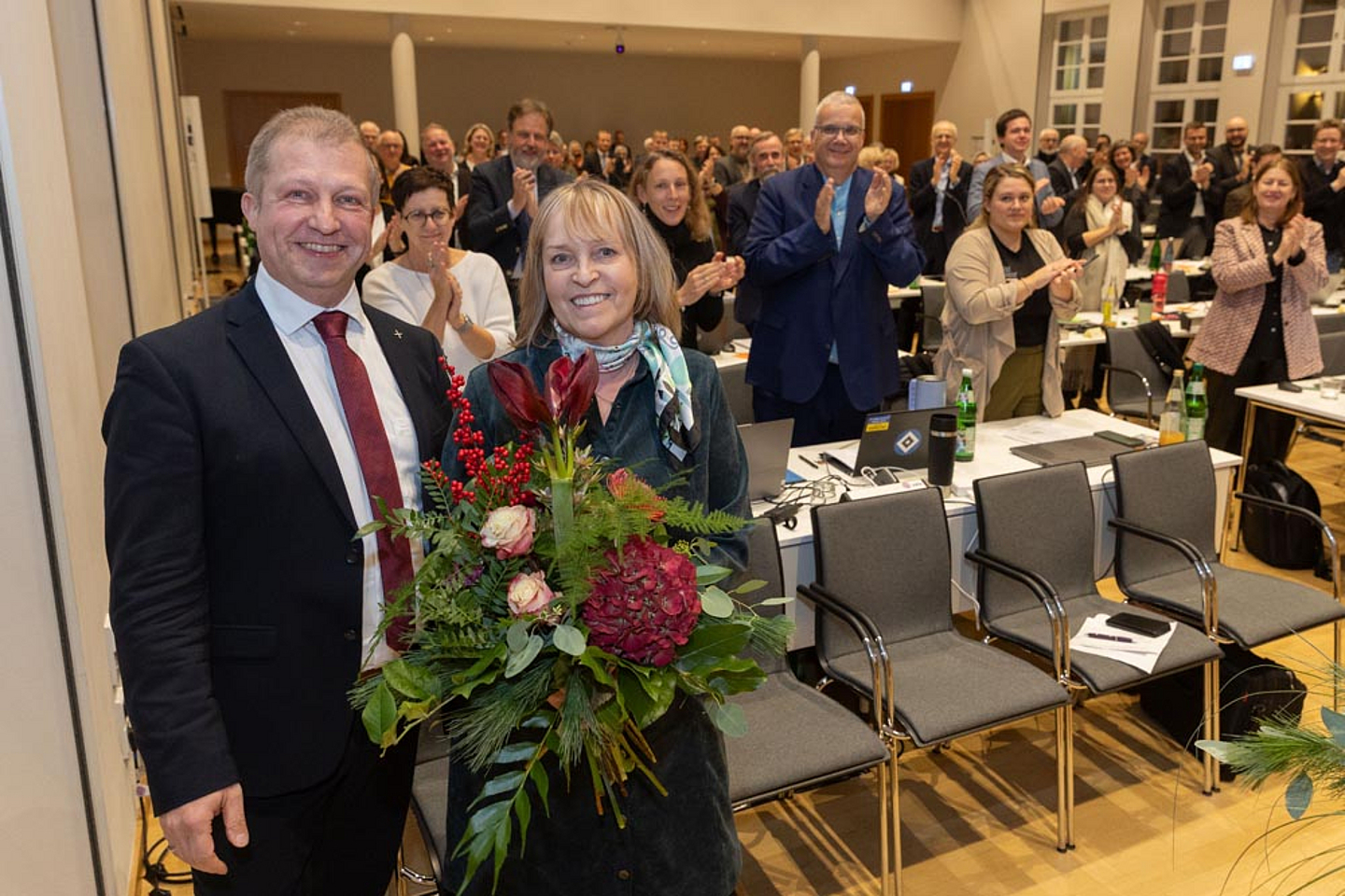 Bettina Groß, Leiterin des Synodalbüros hat seit 1996 die Belange der Synode organisiert, nun tritt sie nach 29 Jahren Synodenarbeit in den Ruhestand. Präses Dr. Michael Schneider (l.) überreichte ihr einen Blumenstrauß und die Synodalen gaben ihr Standing Ovations. 