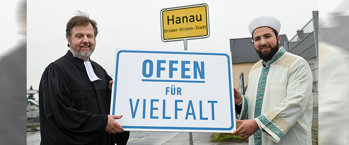 Solidarität zu zeigen und ein Zeichen zu setzen – dazu rufen immer mehr Kirchenkreise der Landeskirche auf. Unser Foto zeigt Dr. Martin Lückhoff, Dekan des Evangelischen Kirchenkreises Hanau, und Mustafa Macit Bozkurt, Imam des Islamischen Vereins Hanau e.V., die die Mitglieder ihrer Religionsgemeinschaften und alle Bürgerinnen und Bürger der Stadt Hanau dazu ermutigen, aktiv bei der Türschild-Kampagne mitzumachen. (Foto: Initiative Offen für Vielfalt / Uwe Zucchi)