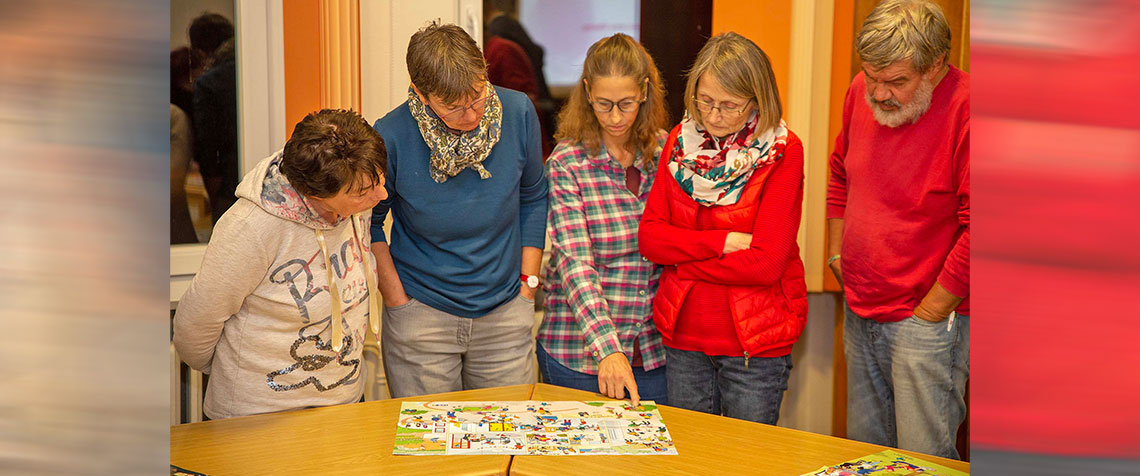 Die Teilnehmenden stellten sich keinem einfachen Thema. Unser Foto zeigt die Männer und Frauen beim diskutieren über Situationen mit Kindern und Jugendlichen. Hilfestellung gaben dabei Wimmelbilder voller Figuren und Details. (Foto: medio.tv/Dellit)