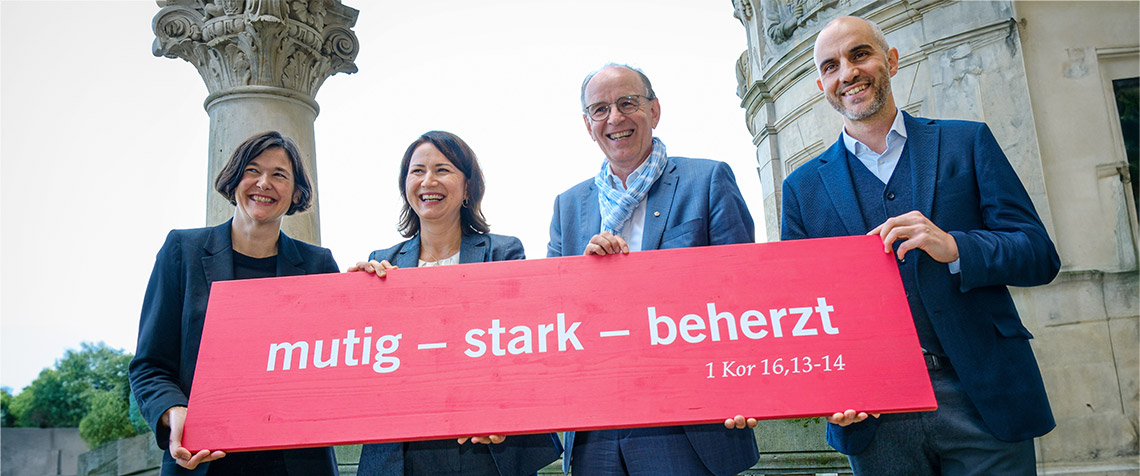 Generalsekretärin Kristin Jahn, Landesbischof der Evangelisch-lutherischen Landeskirche Hannovers Ralf Meister, Kirchentagspräsidentin Anja Siegesmund und Oberbürgermeister der Landeshauptstadt Hannover Belit Onay mit dem Motto des Kirchentags 2025 (Foto: Kirchentag/Jens Schulze)