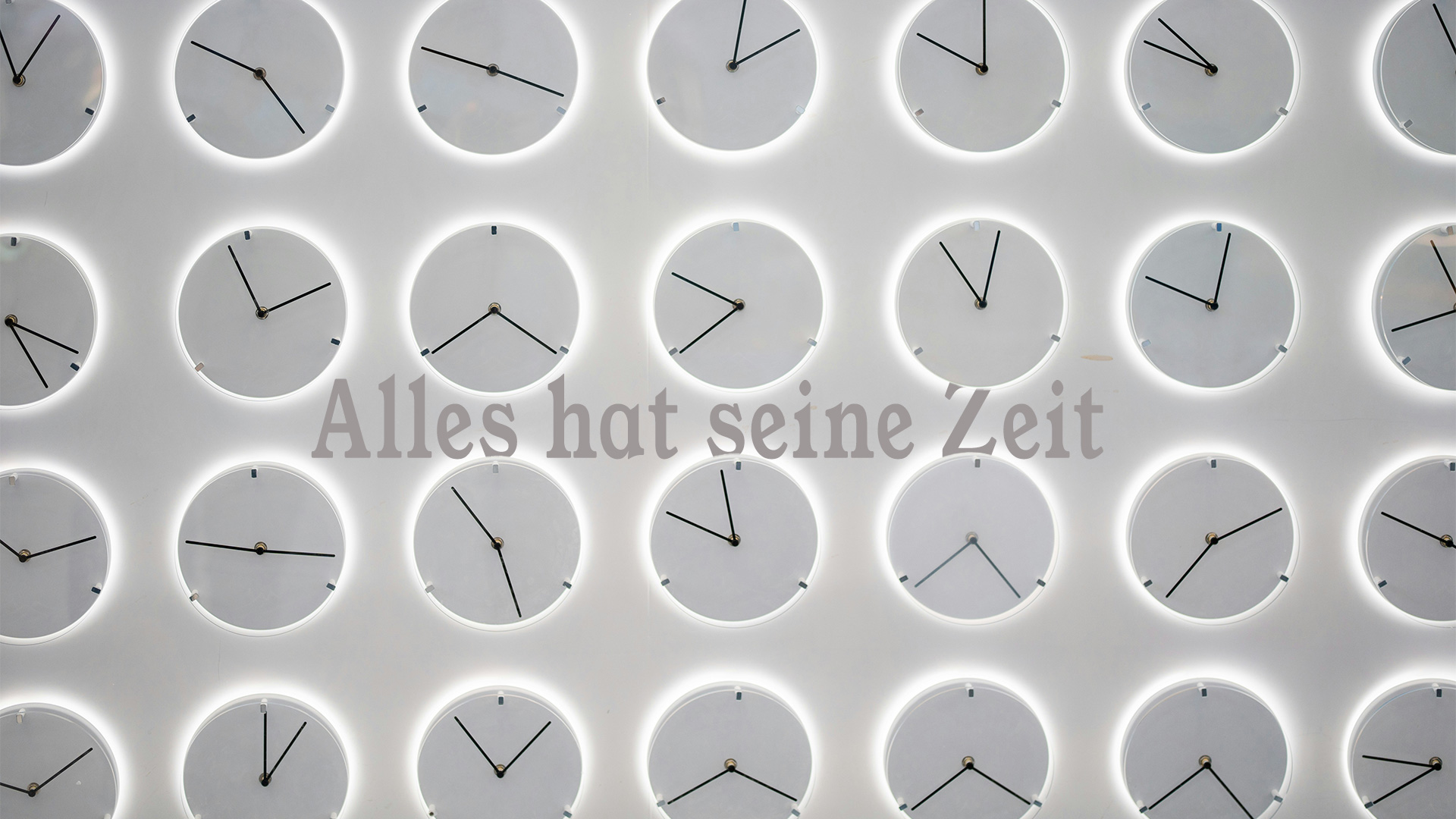 Unser Foto Zeigt eine Wand voller Uhren mit der Aufschrift "Alles hat seine Zeit"