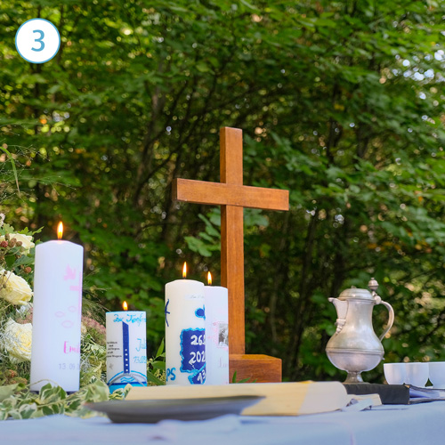 Kreuz und Taufkerzen auf dem Altar im Freien