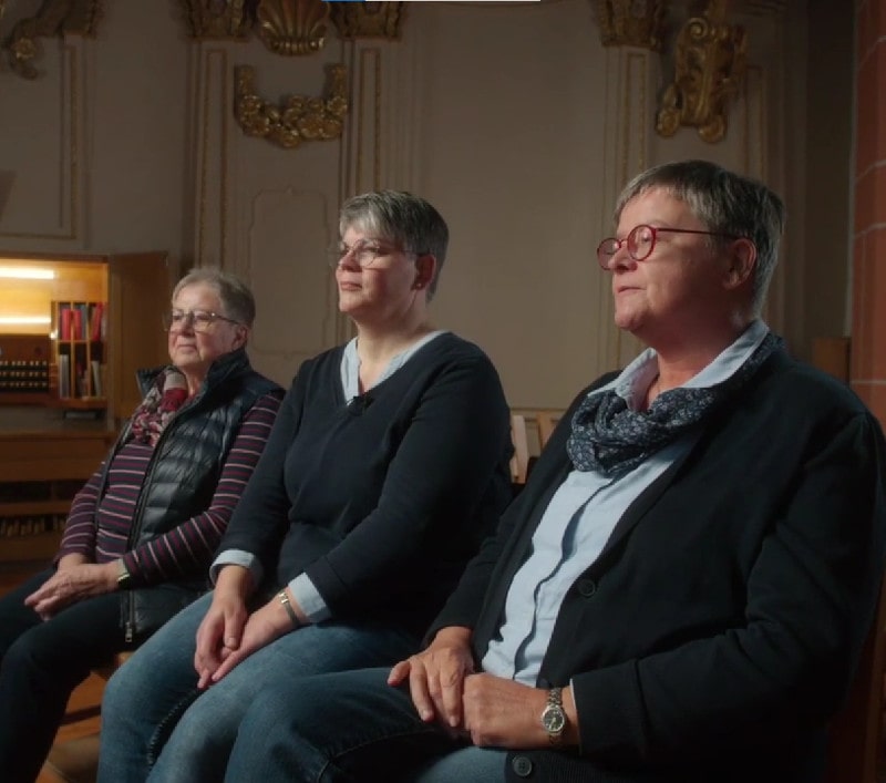 Drei Frauen im Kirchenchor der Kirchengemeinde Franz von Roques, Treysa, nennen ihre Wünsche an den Kirchenraum. Foto: Screenshot Video.