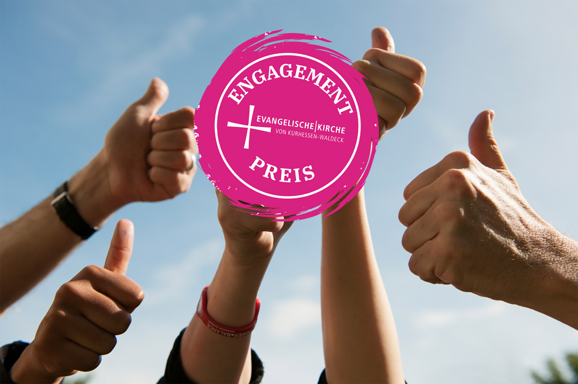 Unser Foto zeigt Hände mit der Daumen-hoch-Geste und das Logo des Preises 