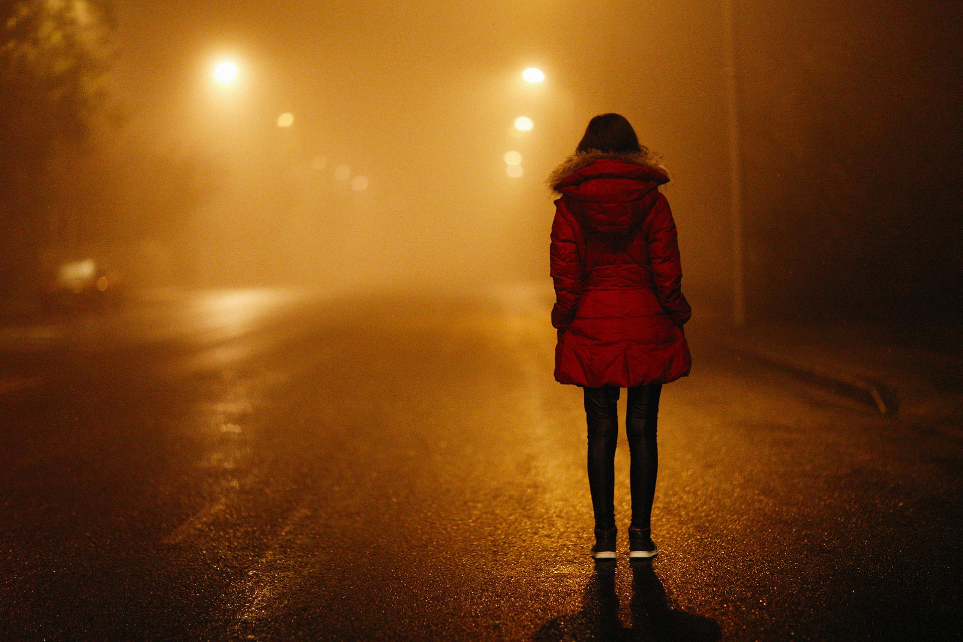 Unser Foto zeigt eine Frau auf einer düsteren Straße