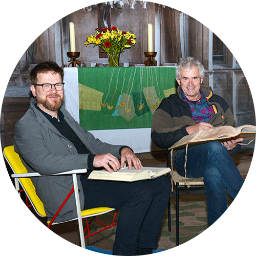 Pfarrer Matti Fischer sitzt links in einem finnischen Schaukelstuhl, neben ihm Norbert Zander von St. Peter und Paul. Beide haben die Non-Stop-Bibellesung in der Elisabethkirche Marburg vorbereitet und freuen sich auf die Aktion. Das Foto zeigt Pfarrer Matti Fischer, der links in einem original finnischen Schaukelstuhl sitzt, und Norbert Zander von der katholischen Gemeinde St. Peter und Paul. Sie haben gemeinsam mit anderen Gläubigen die Non-Stop-Bibellesung in der Elisabethkirche Marburg vorbereitet und blicken erwartungsvoll auf die bevorstehenden drei Tage und Nächte, in denen die Kirche als Erfahrungsraum genutzt wird.