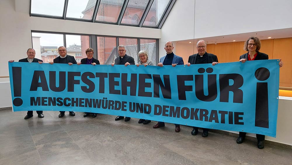 Zeigen gemeinsam Flagge: Die leitenden Geistlichen der evangelischen Landeskirchen und katholischen Bistümer in Hessen und Rheinland-Pfalz sowie der Arbeitsgemeinschaften Christlicher Kirchen Südwest und Hessen-Rheinhessen, darunter Bischöfin Beate Hofmann von der Evangelischen Kirche von Kurhessen-Waldeck (3.v.l.)
