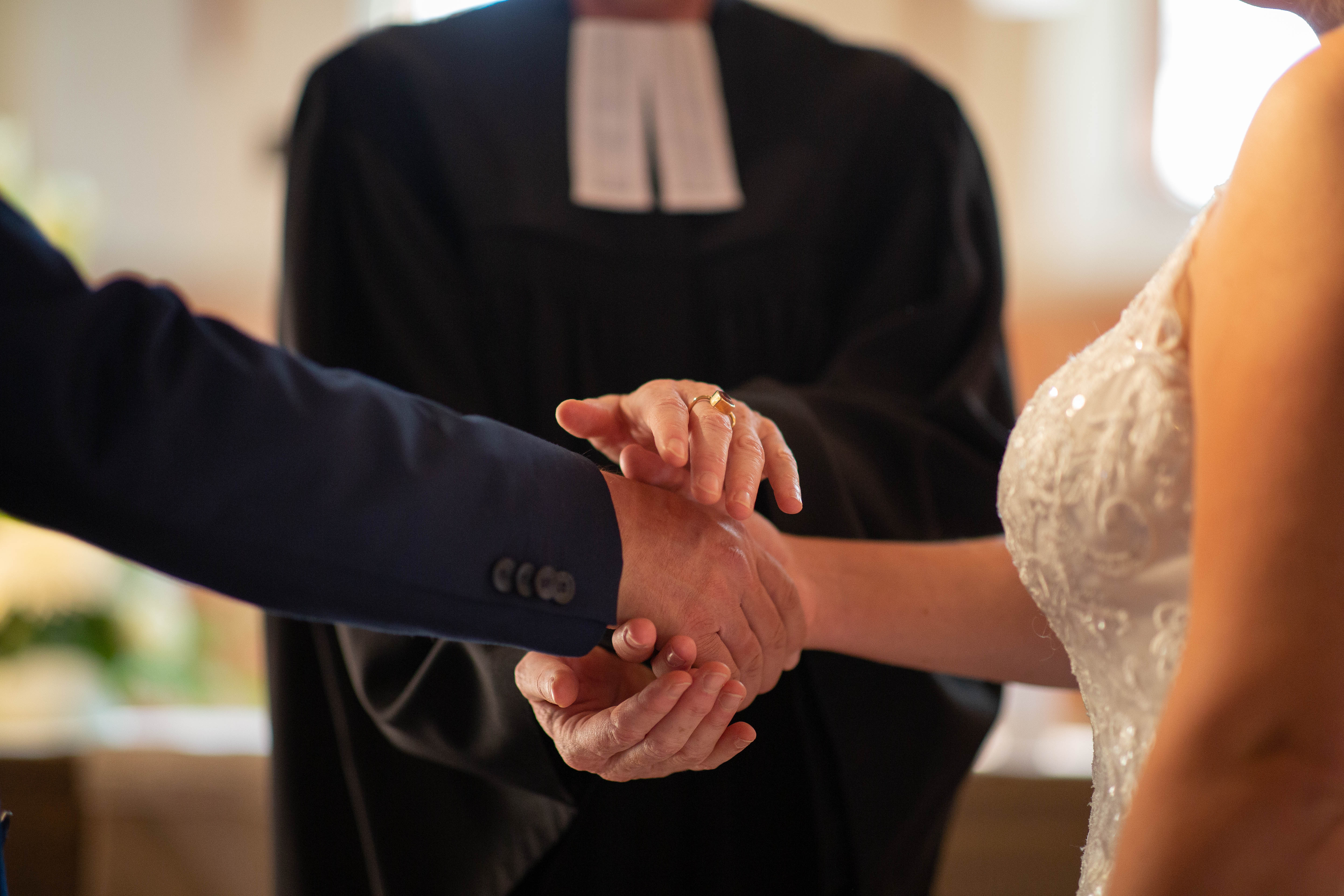 Eine Pfarrerin segnet das Paar.